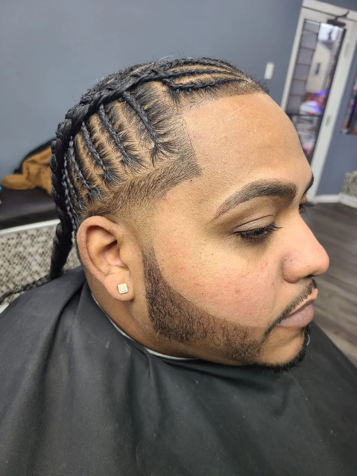 Trenzas con línea frontal y barba perfilada en El Pequeño Barbershop, Reading PA